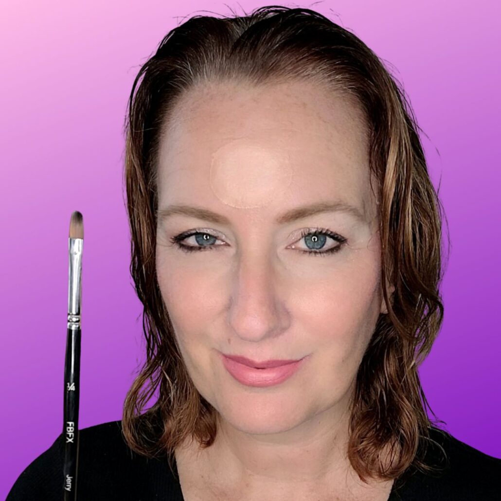 Begin van de Labubu schmink look met huidskleur basis op het voorhoofd, aangebracht met een FBFX penseel, te zien bij SchminkenGrime.nl