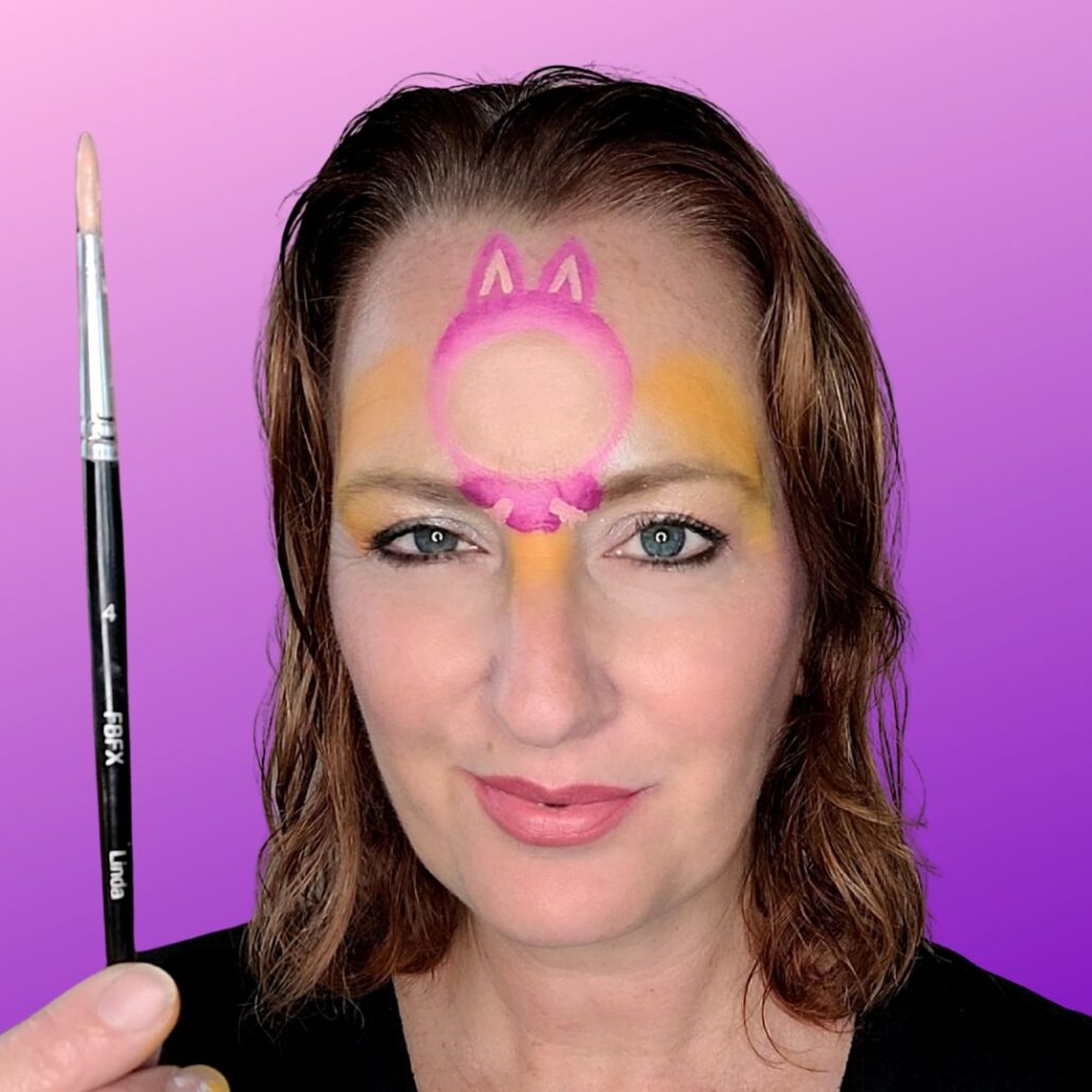 Inkleuren van handjes en oren bij de Labubu schmink met FBFX penseel Linda nr 2, onderdeel van een creatieve Halloween schmink look