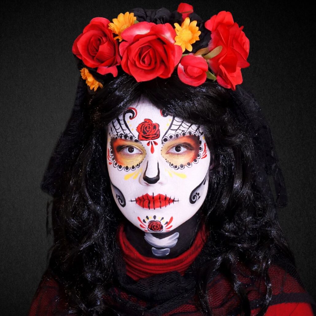 Compleet Day of the Dead schmink voorbeeld met bloemen en zwarte pruik, verkrijgbaar bij SchminkenGrime.nl