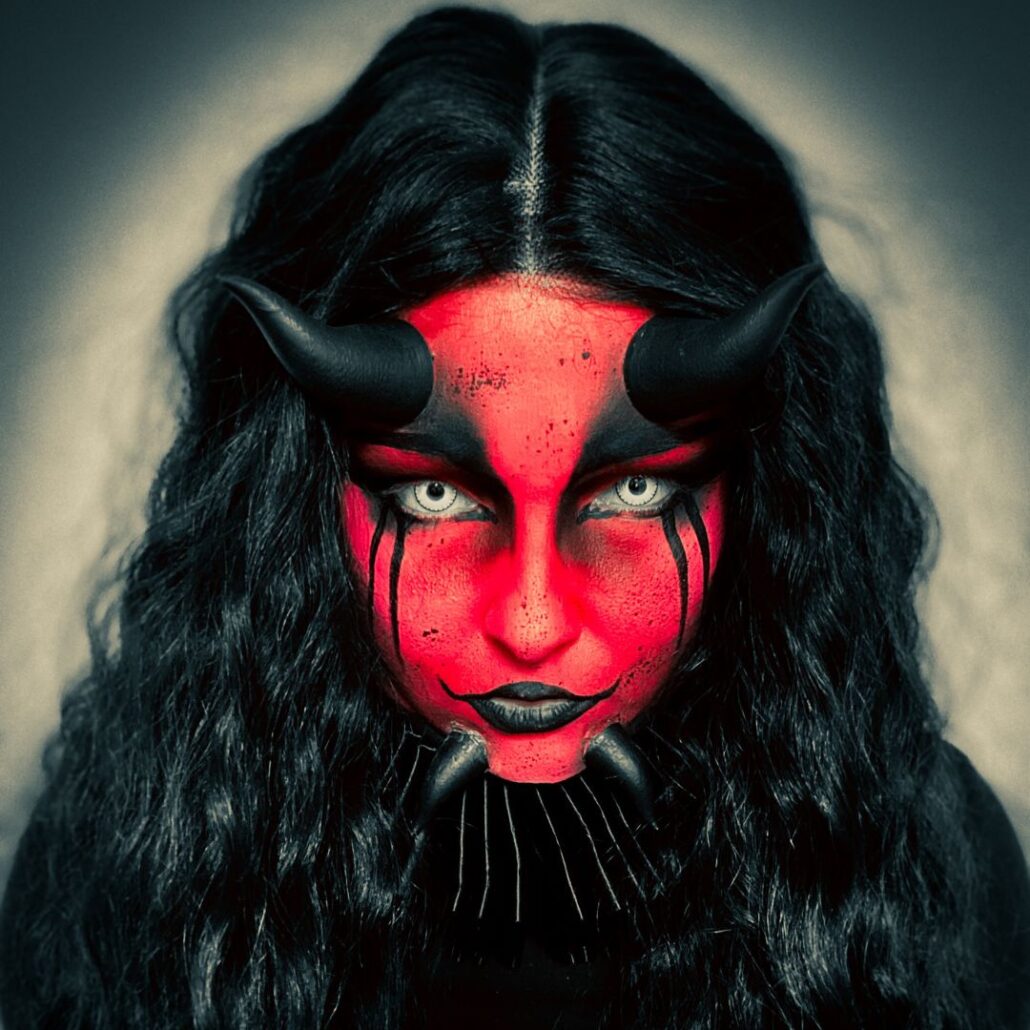 Compleet eindresultaat van demon schmink look met hoorns en zwarte krullen, verkrijgbaar bij SchminkenGrime.nl