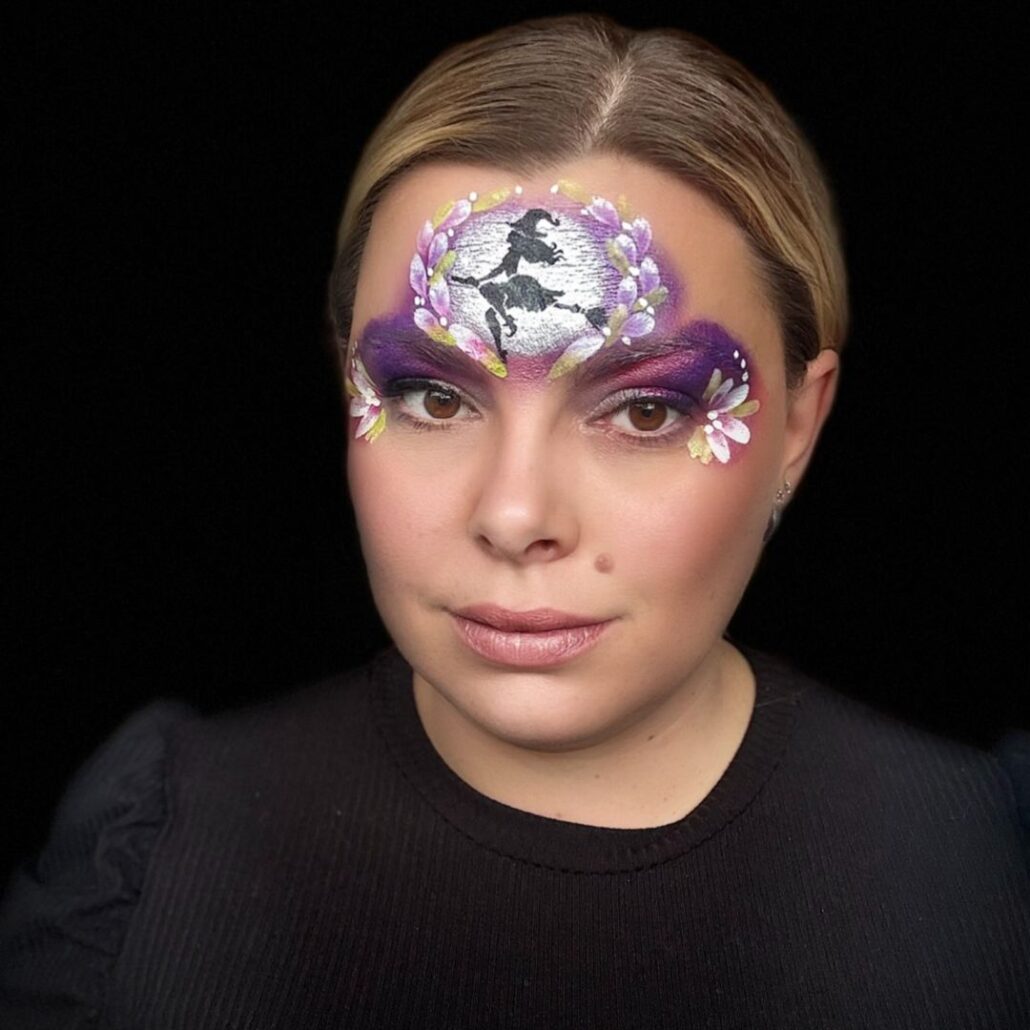Heks kinderschmink met bloemenkrans en witte highlights, paars-roze Halloween schmink voorbeeld, verkrijgbaar bij SchminkenGrime.nl