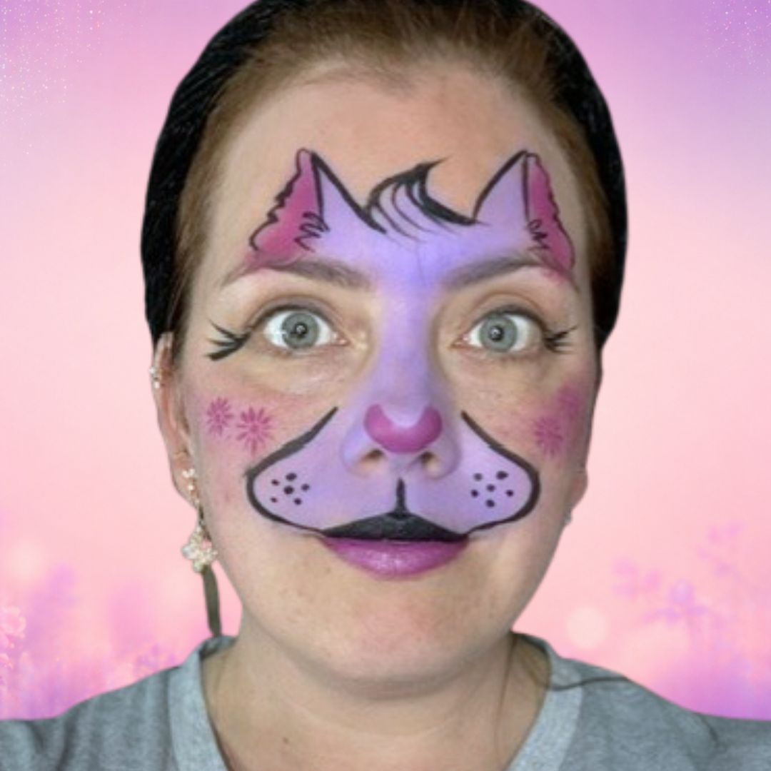 Stap 3 van de kat schminken: magenta kattenneus gezet met een FBFX Jerry 1/4-penseel en bloemetjes op de wangen via het Superstar Flowerpower-sjabloon, verkrijgbaar bij SchminkenGrime.nl.