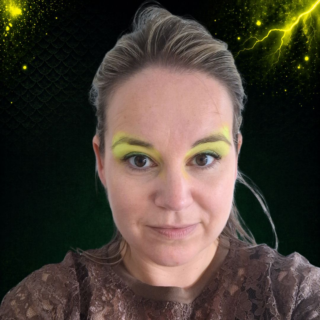 Neon gele schmink-basislaag op ooglid met groen petal sponsje, eerste stap van draak schminken met Mehron Paradise Neon UV Stardust Yellow, verkrijgbaar bij SchminkenGrime.nl