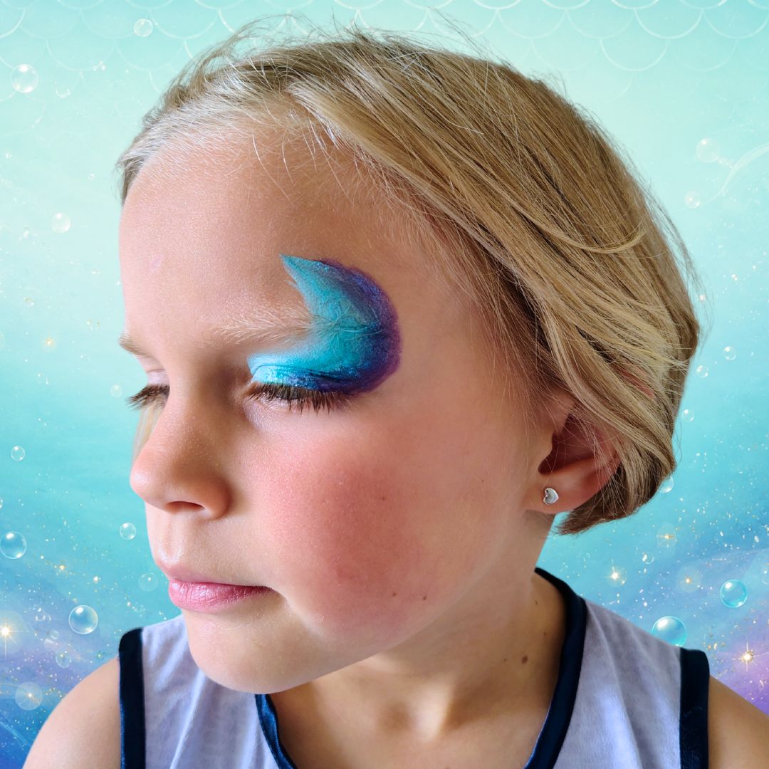 Basis van de zeemeerminstaart geschminkt vanaf de binnenste ooghoek over het ooglid met de Superstar Little Mermaid splitcake en het FBFX Simone 1 inch schuin penseel, verkrijgbaar bij SchminkenGrime.nl