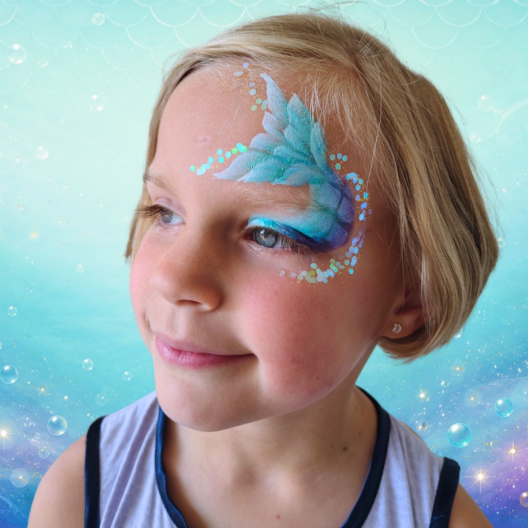 Witte schubben gestempeld via het Superstar sjabloon Scales op de zeemeerminstaart met een vingersponsje en Diamond FX Essential White, verkrijgbaar bij SchminkenGrime.nl