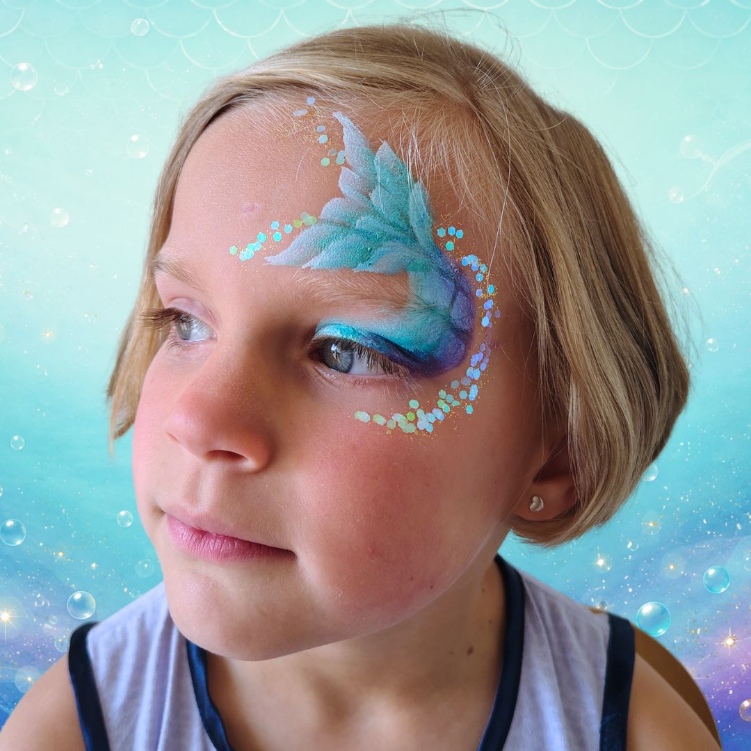 Chunky glitter aangebracht langs de zeemeerminstaart en op de toppen van de vinnen met de FBFX Siliconen Glitter Applicator en de PXP Chunky Glitter Cream Iceberg White, verkrijgbaar bij SchminkenGrime.nl