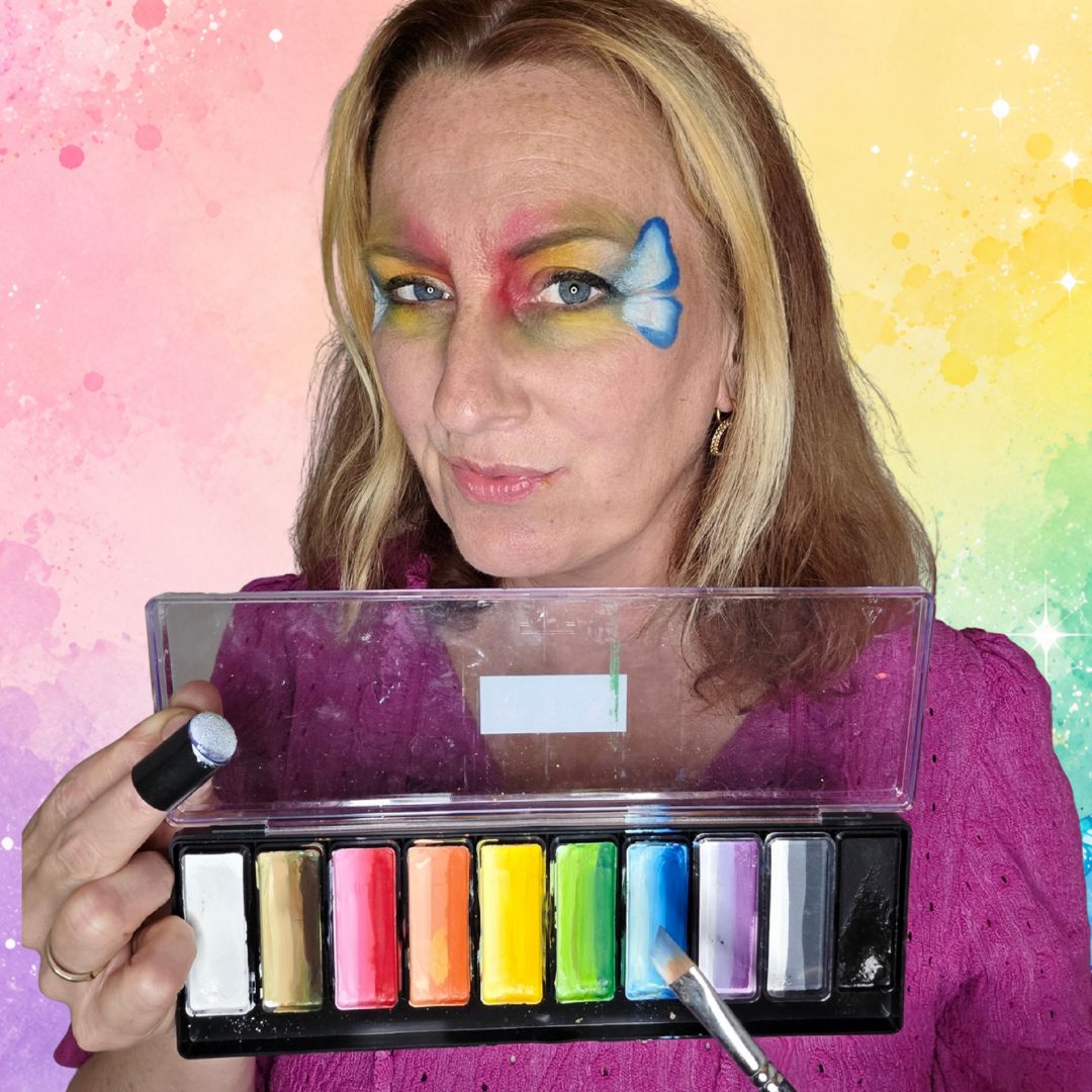 Blauwe vleugels van een regenboog vlinder geschminkt naast het oog met de FBFX Simone 1/2 schuin penseel, donkerste kant naar buiten, verkrijgbaar bij SchminkenGrime.nl.