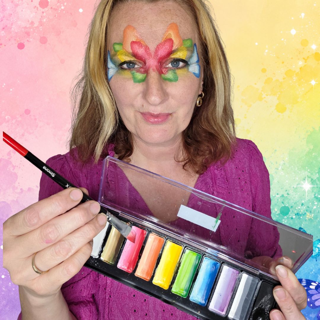 Rode vleugels tussen de ogen op het voorhoofd als hart van de regenboog vlinder, waar de linker- en rechtervleugels samenkomen tot één ontwerp, verkrijgbaar bij SchminkenGrime.nl.