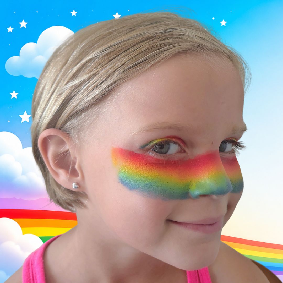 Regenboog doorgetrokken vanaf de ooghoek over de neus met een halve grimeerspons en de Real Rainbow splitcake, verkrijgbaar bij SchminkenGrime.nl