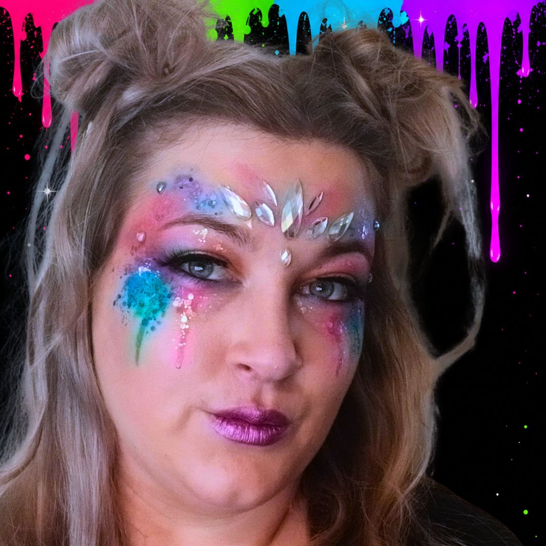 De complete festival glitter make-up met glitter, strass steentjes, neon druppels en nepwimpers, afgewerkt met losse haarknotjes, verkrijgbaar bij SchminkenGrime.nl.
