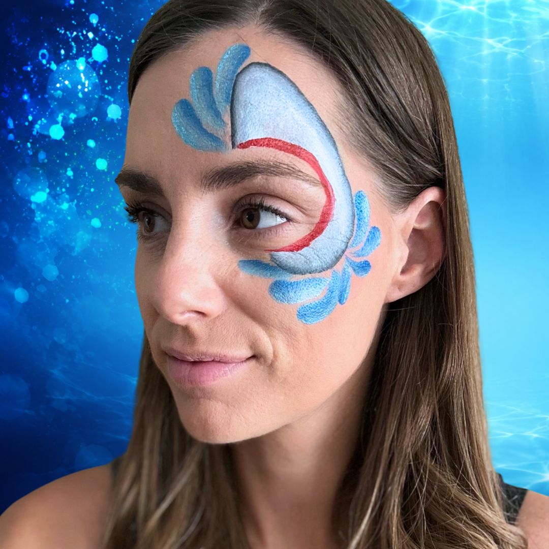 Blauwe waterdruppels en spatten geschminkt rondom de haaienkop met de Diamond FX splitcake Elsa's Magic en het FBFX Jerry filbert penseel, verkrijgbaar bij SchminkenGrime.nl
