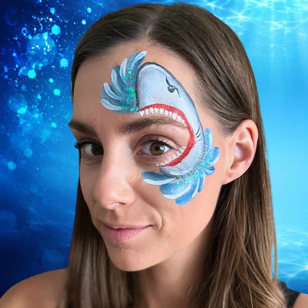 Afgemaakt haai eye design rond het oog met blauwe glitter op het water, geschminkt met PXP Chunky Glitter Cream Heavenly Blue, verkrijgbaar bij SchminkenGrime.nl