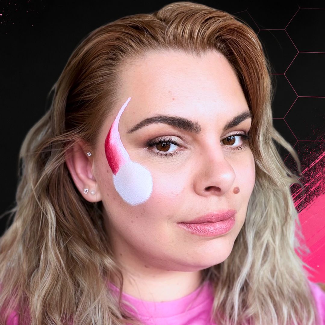 Schuine roze kleurveeg vanaf de slaap richting de wang langs de witte cirkel, tweede stap met Evil Rose uit de Splitcake Palette Glow en het FBFX Simone schuine penseel, verkrijgbaar bij SchminkenGrime.nl