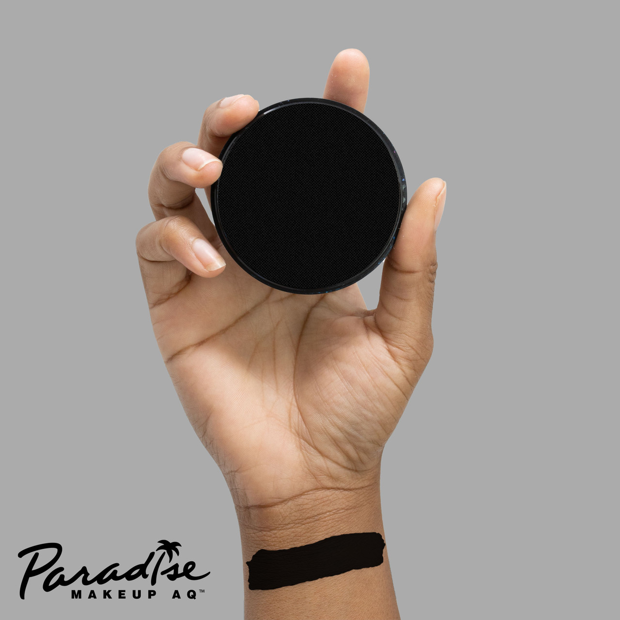 Mehron Paradise Black 40gr – zwarte schmink op hand, verkrijgbaar bij SchminkenGrime.nl Volledig met zwart geschminkte hand met Mehron Paradise Makeup Black 40 gram, laat de intense dekking van de waterschmink zien, verkrijgbaar bij SchminkenGrime.nl
