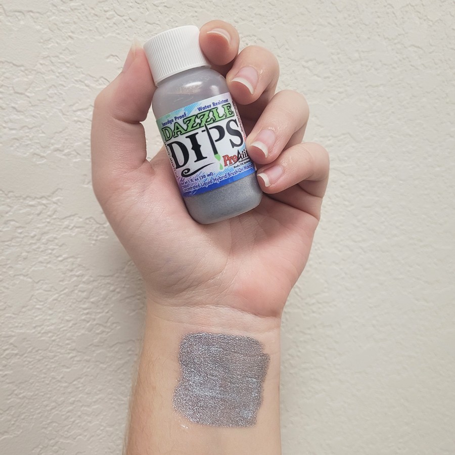 ProAiir Dazzle Dips Silver swatch – metallic schmink | SchminkenGrime.nl Swatch van ProAiir Dazzle Dips Silver op de huid, glanzende zilveren schmink, verkrijgbaar bij SchminkenGrime.nl