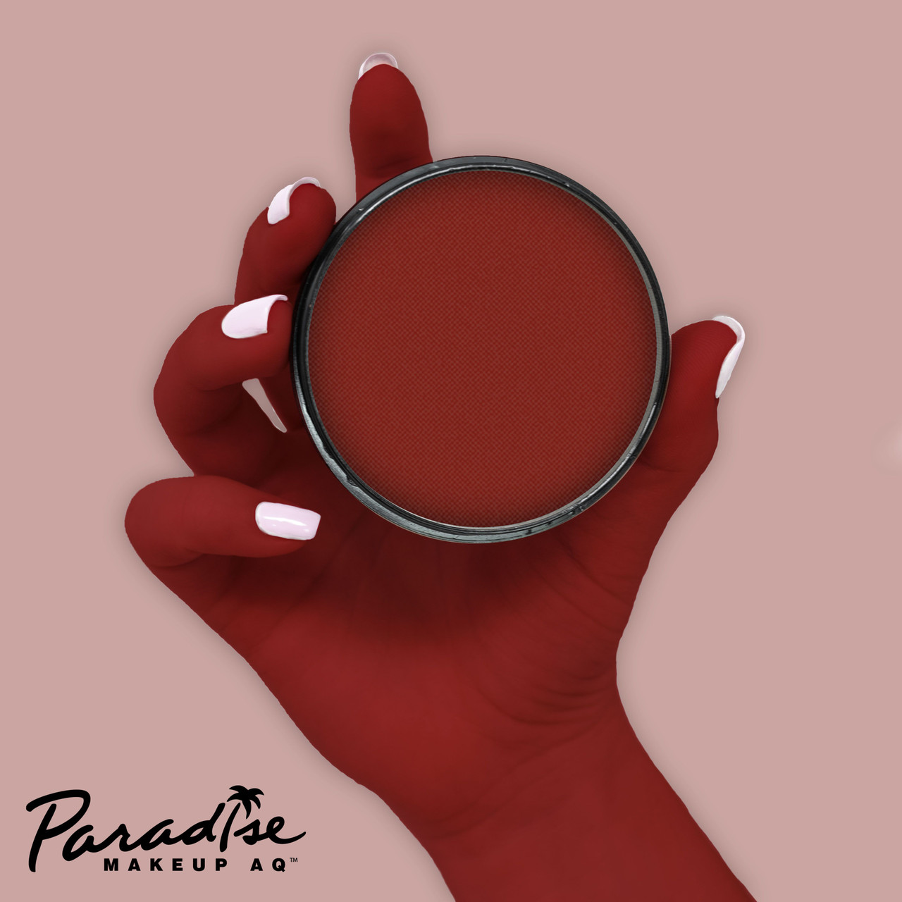 Mehron Paradise Red 40gr – schmink op hand, verkrijgbaar bij SchminkenGrime.nl Rode schmink van Mehron Paradise op hand aangebracht met verpakking, toont de sterke pigmentatie en dekking van deze waterschmink, verkrijgbaar bij SchminkenGrime.nl