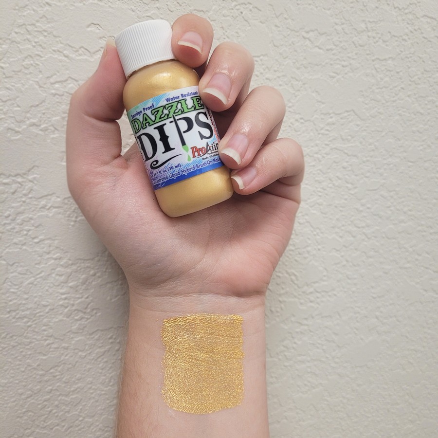 Swatch ProAiir Dazzle Dips Gold 30ml – verkrijgbaar bij SchminkenGrime.nl Gouden metallic schmink – swatch van ProAiir Dazzle Dips Gold op de huid, verkrijgbaar bij SchminkenGrime.nl